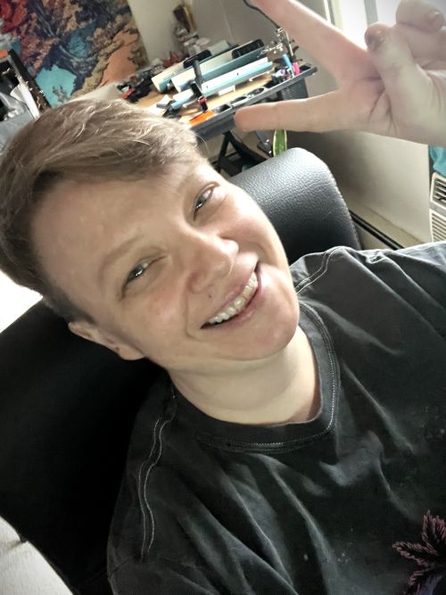 image of a smiling Lucky looking at the camera and laughing wearing a vaporwave shirt